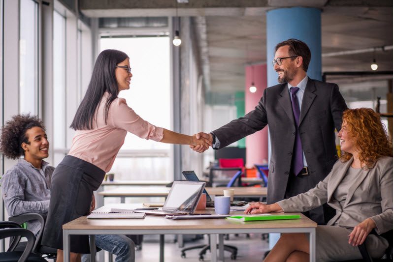 Two business teams successfully negotiating, shaking hands