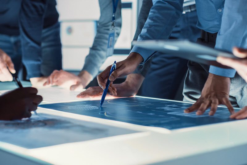 Team gathered Around Illuminated Conference Table