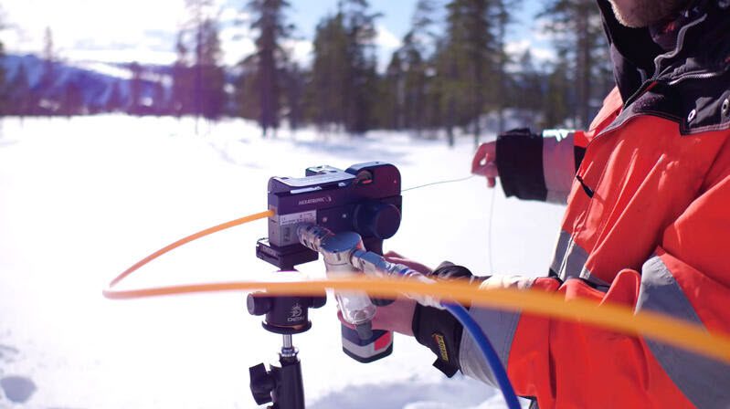 Man checking connections on field with snow