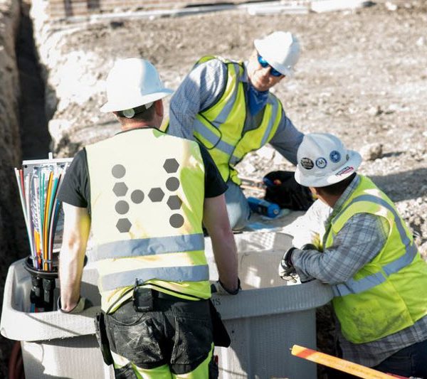 Three men installing fibre connections underground