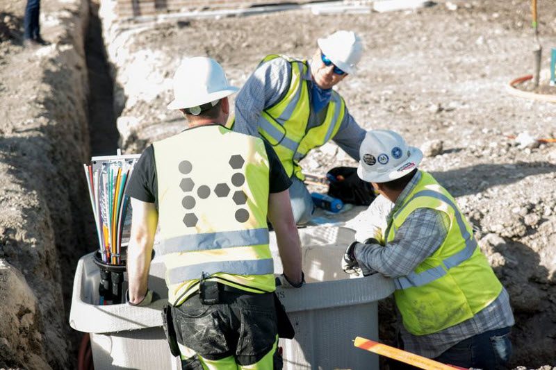 Three men installing fibre connections underground