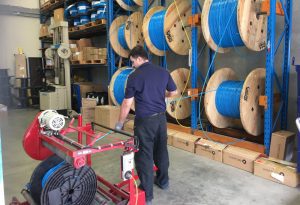 Man fixing fibre cables in warehouse